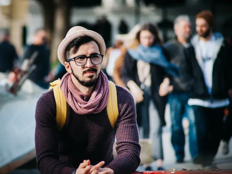 Man with a hat sitting outside